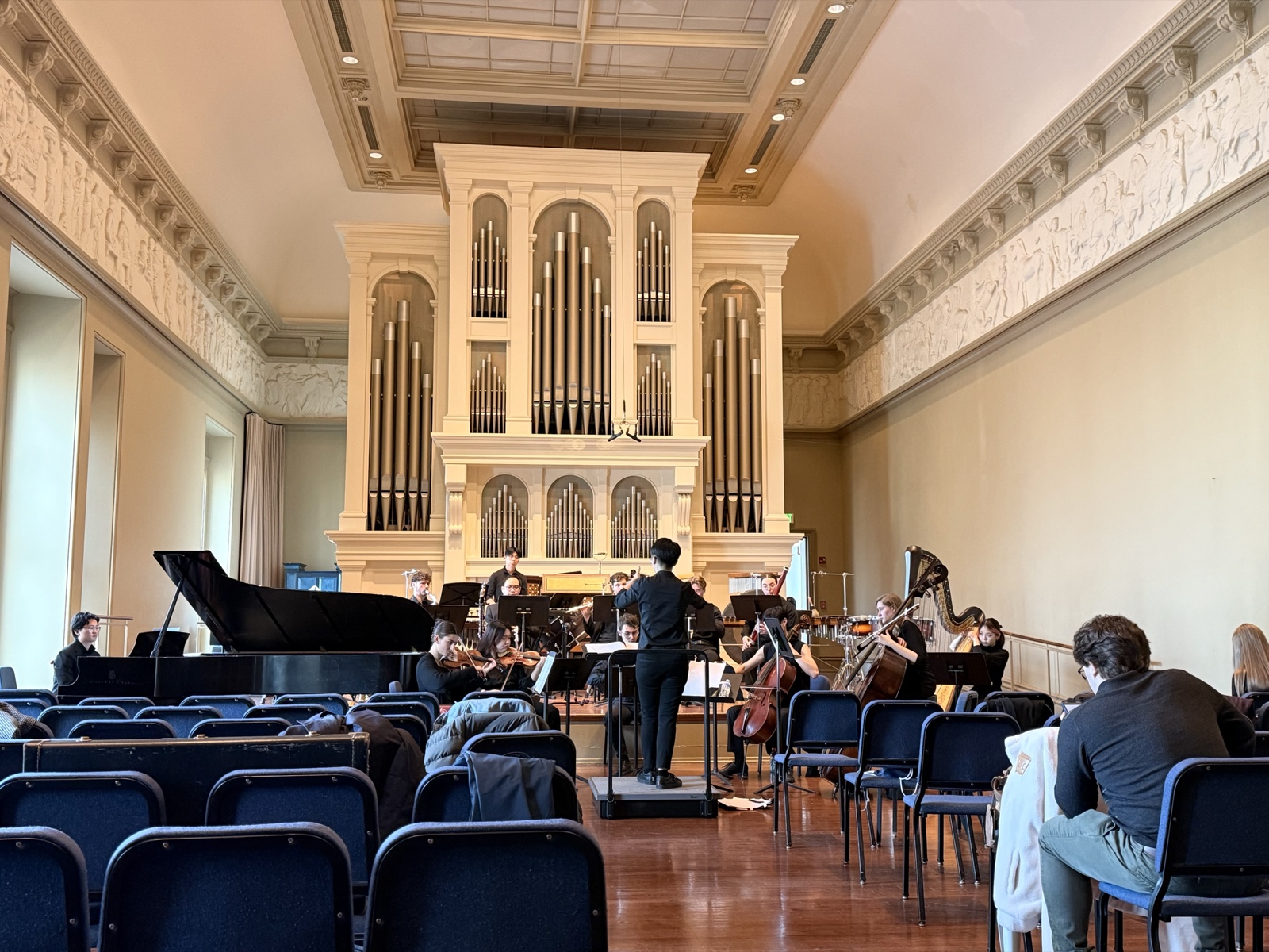 Conductor and ensemble rehearsing in a hall with a pipe organ