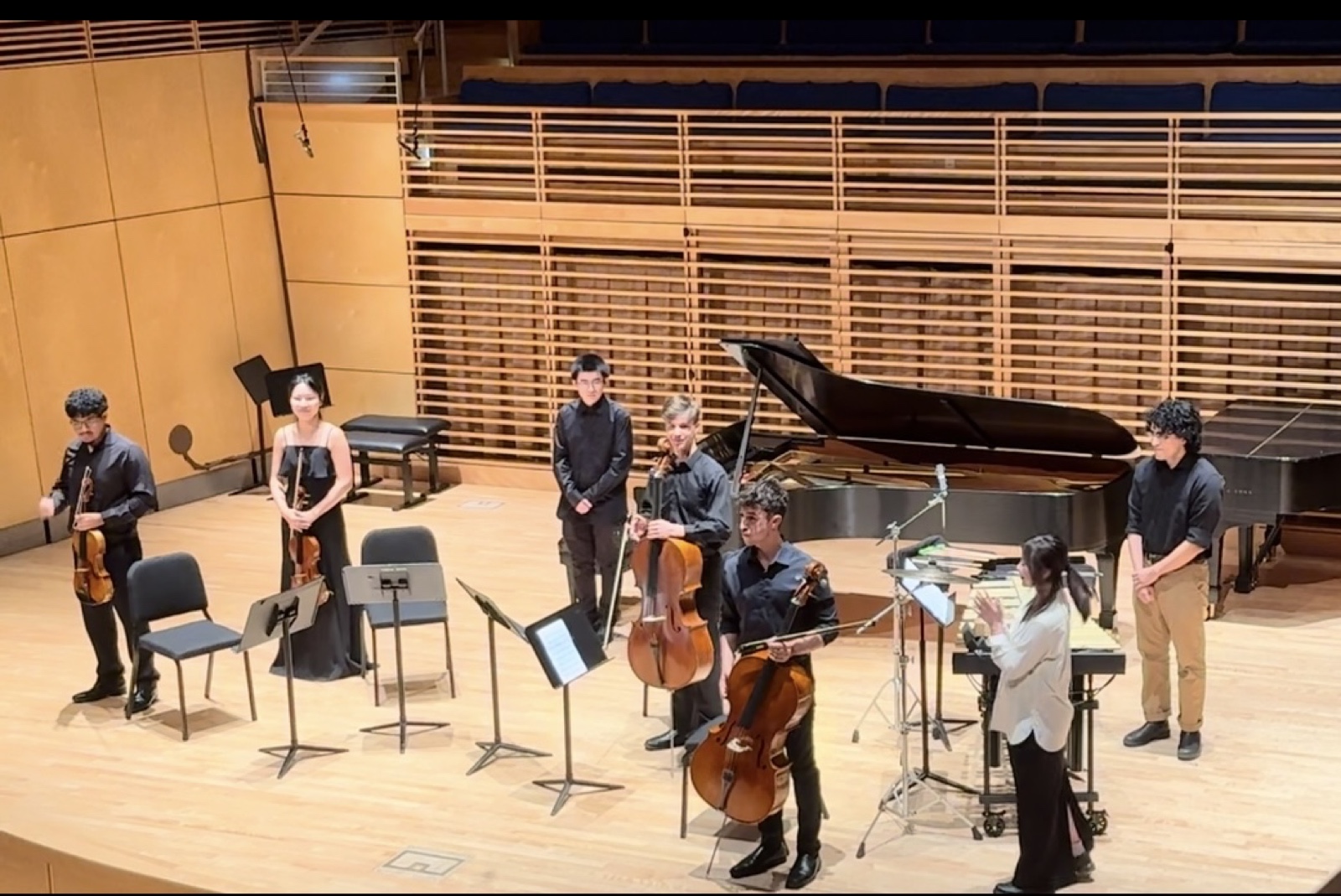 Mixed chamber ensemble bowing on stage after a performance